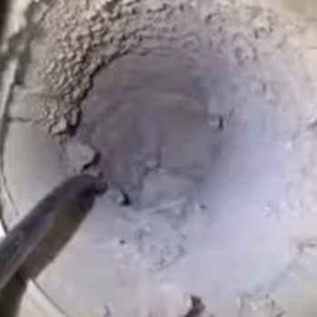 Circular duct filled with debris needing to be cleaned 