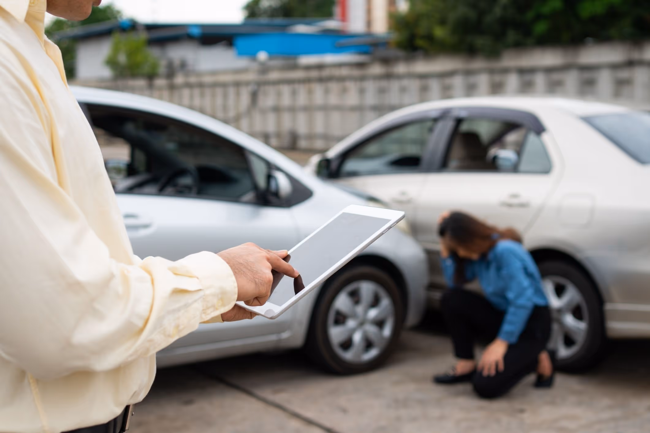 Man involved in a car accident taking photos of the scene, highlighting the need for a Deerfield Beach car accident lawyer.