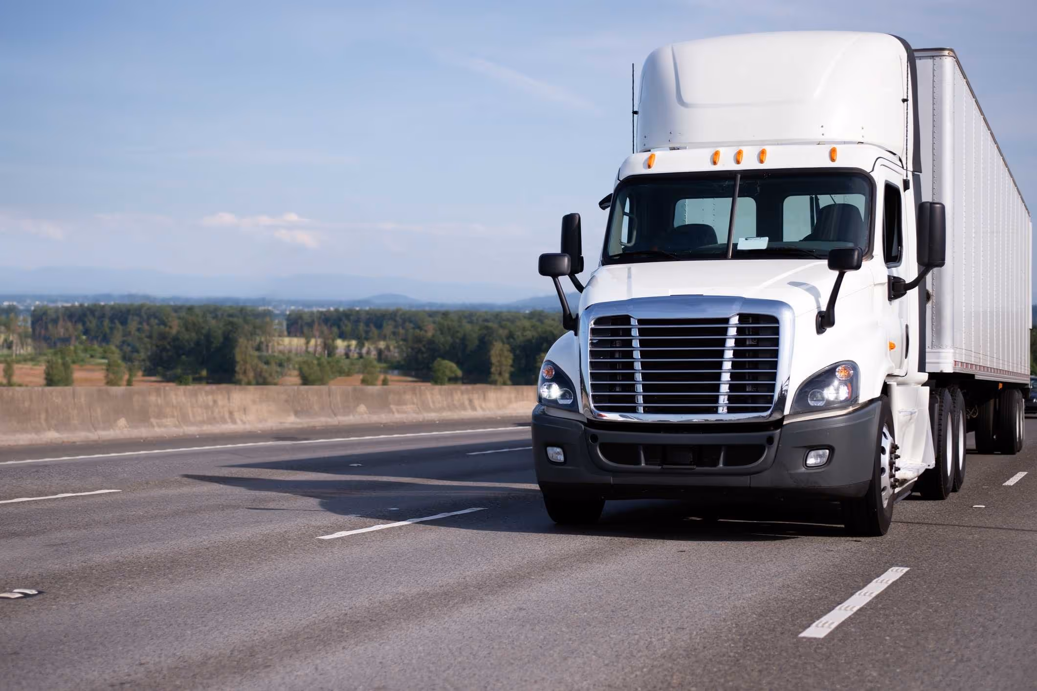 White semi-truck traveling on Florida highway, representing the role of a Delray Beach truck accident lawyer.