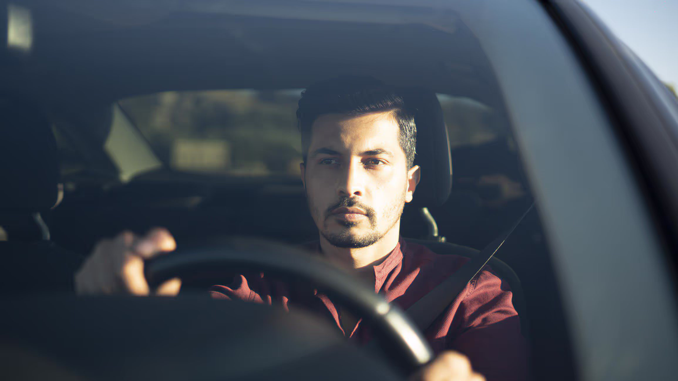 A driver focuses while driving his car. 