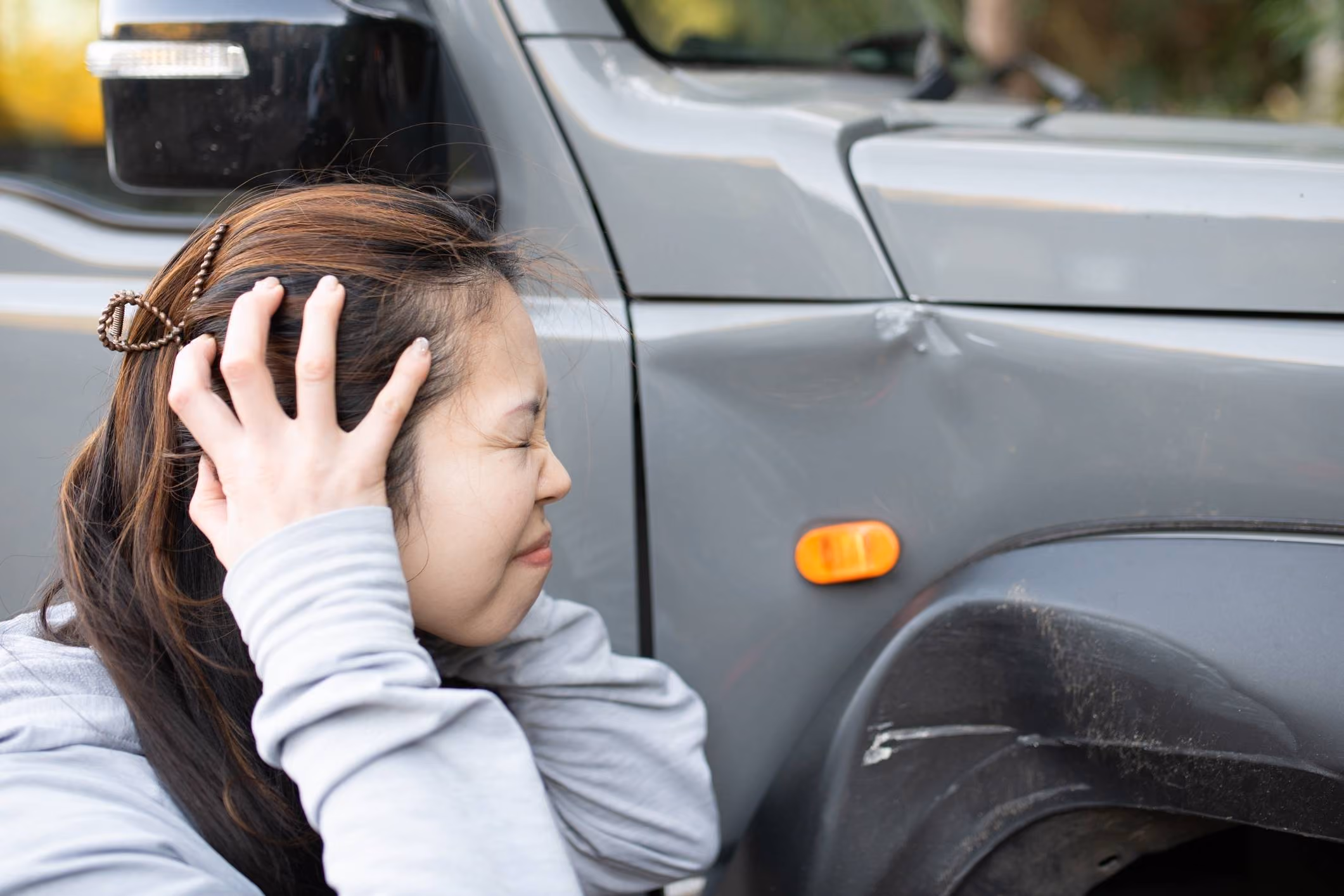Woman holding her side after a crash, showing signs of internal injury after a car accident.