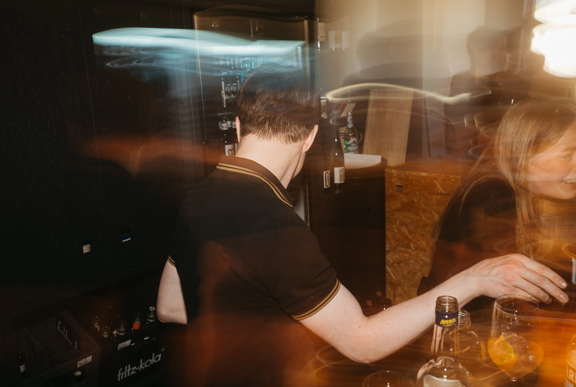 Kolleginnen stehen nach Feierabend bei einem Glas Aperol zusammen und unterhalten sich fröhlich.
