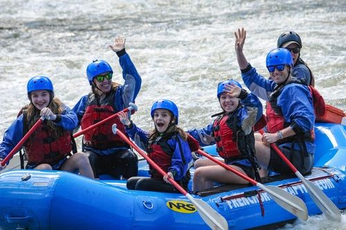 family with young children enjoying whitewater rafting