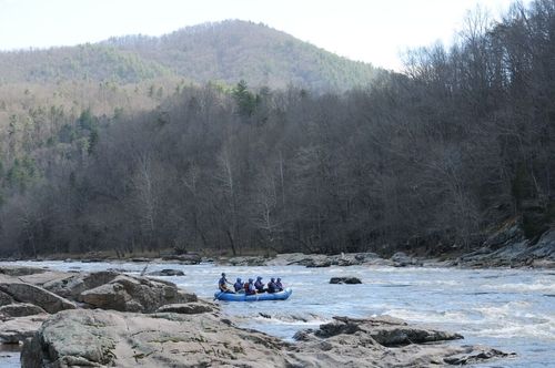 view of raft on French Broad River with mountain in back