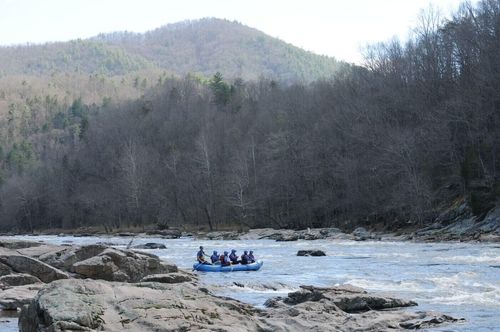 Raft in the distance on river with mountain view