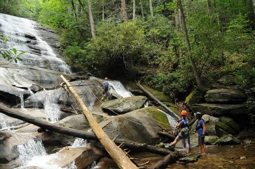 canyoneers at bottom of waterfall looking up