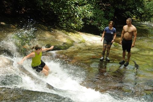 woman sliding down rock slide