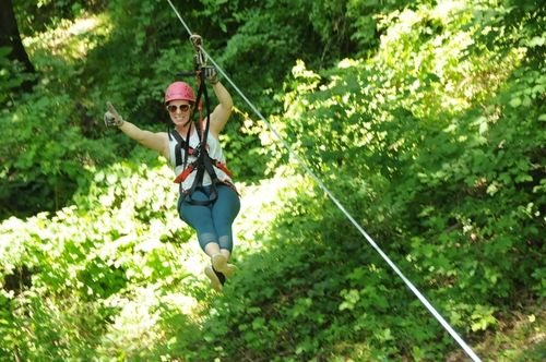 Woman ziplining through trees