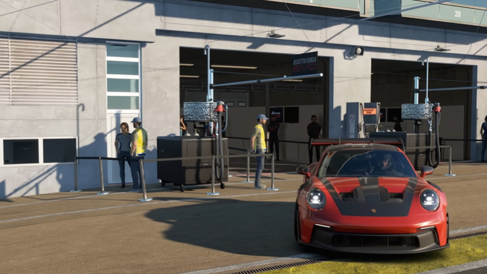 Red ACC car parked in the pit with staff standing by