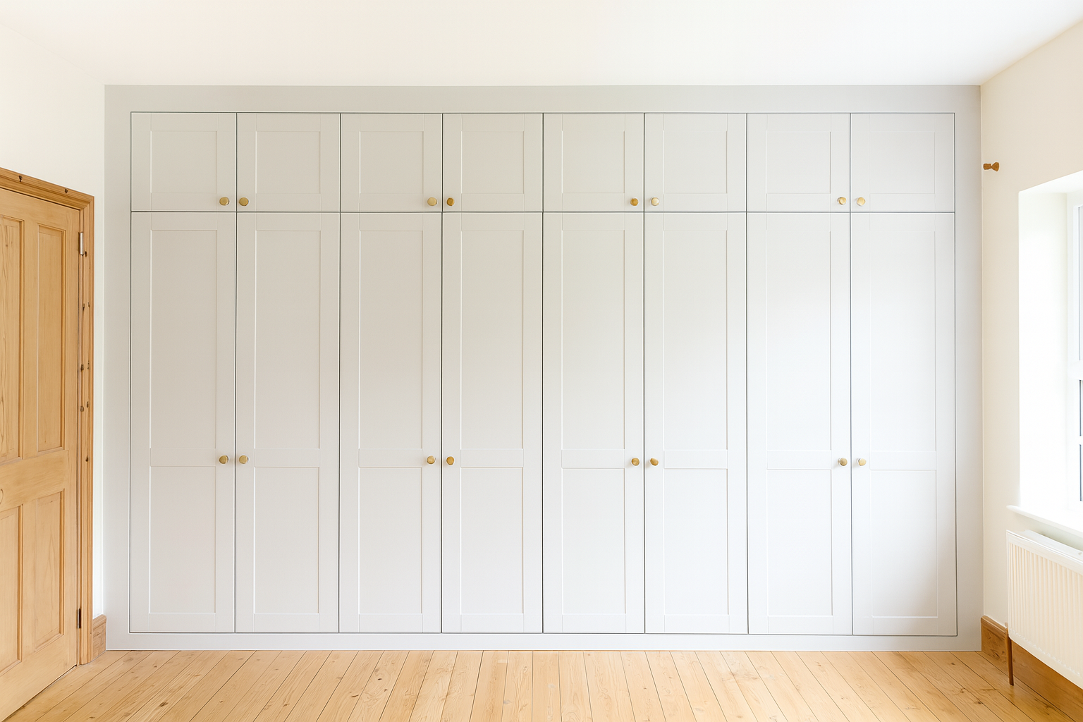 large wall to wall bespoke fitted wardrobe in a light grey colour