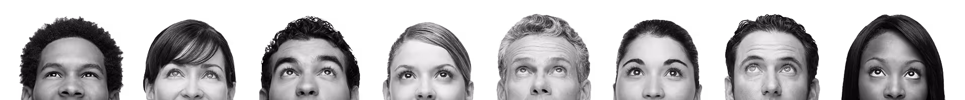 Close-up of seven diverse young adults looking upwards with curious expressions.