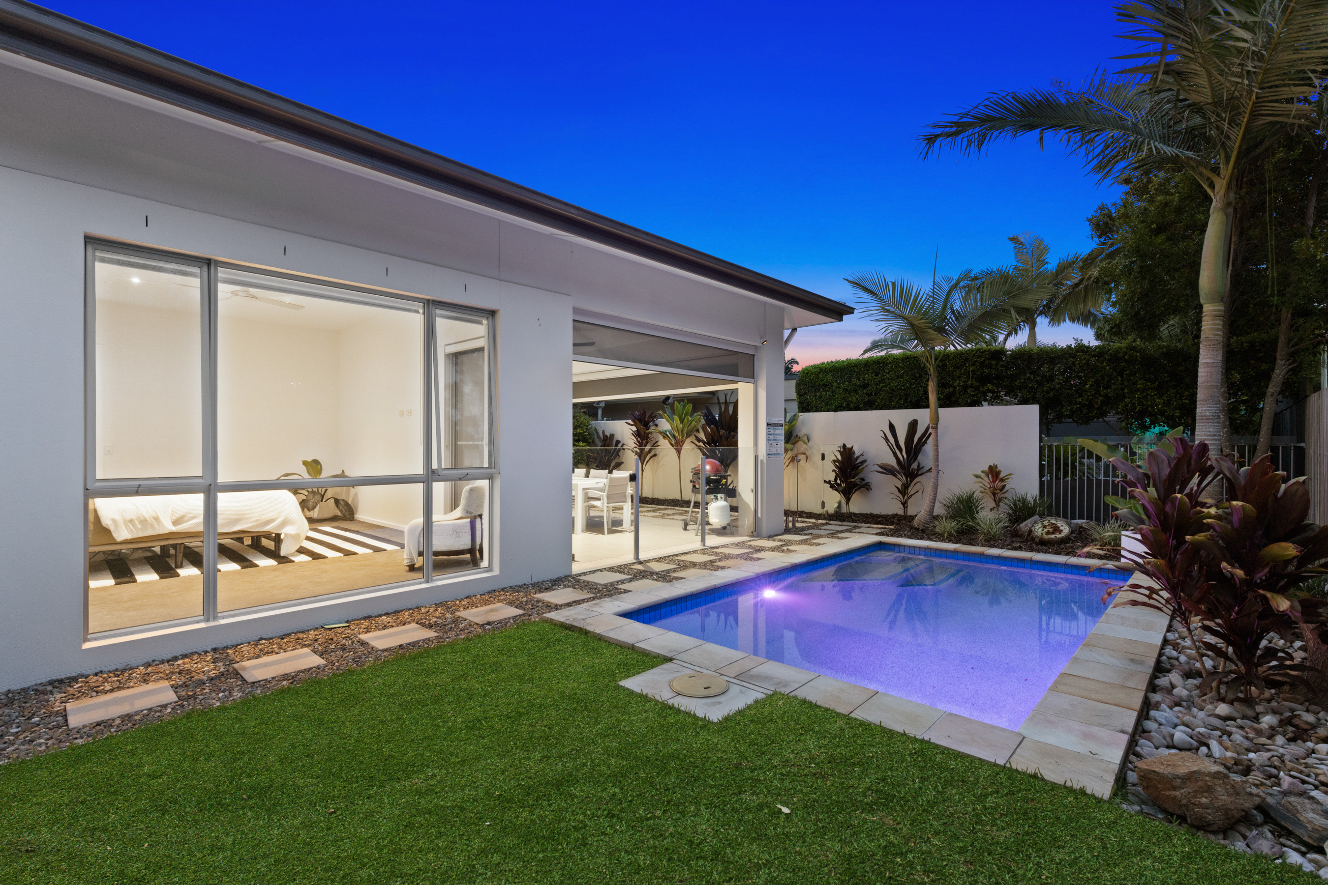 Residential backyard and swimming pool photographed at twilight