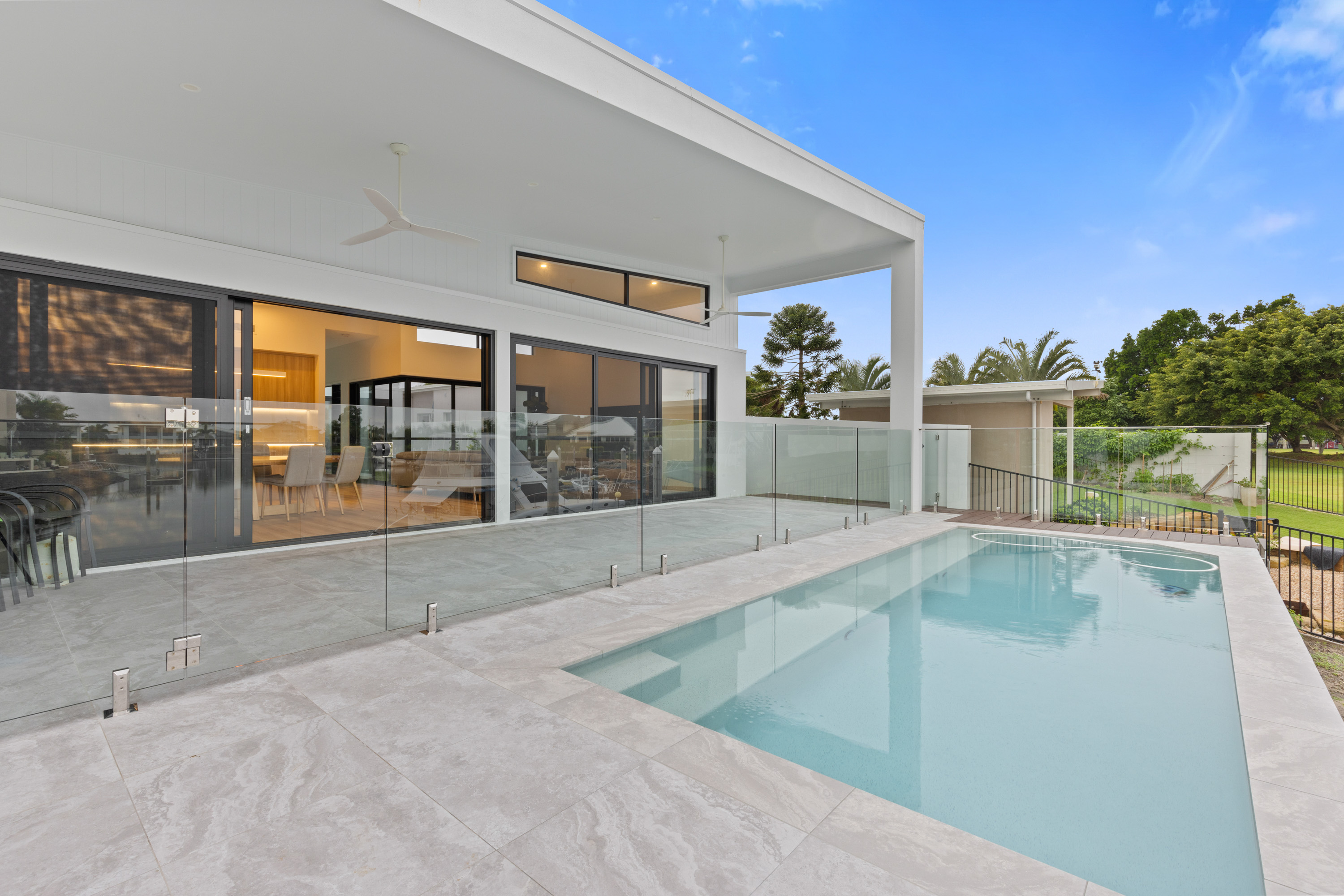 Modern home exterior with backyard swimming pool and patio