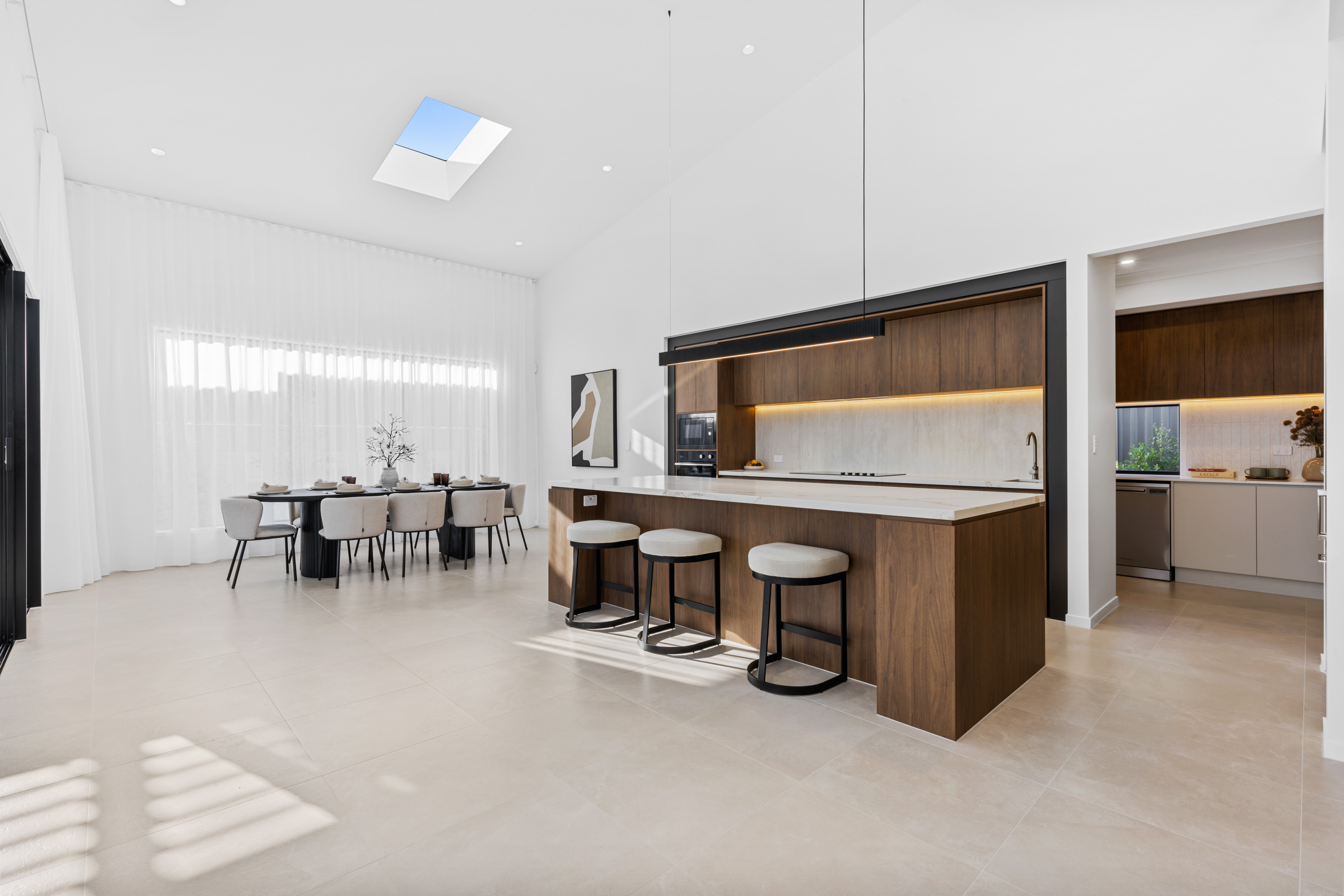 Modern custom home kitchen and dining area with timber cabinetry