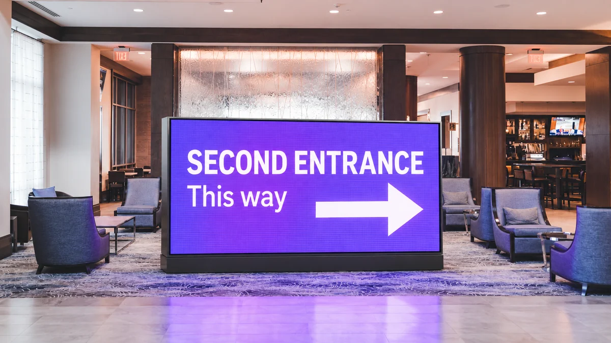 A hotel lobby with an illuminated LED installation directing visitors to the second entrance