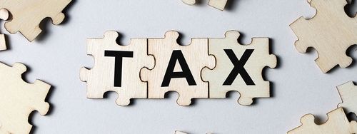 the word tax written on puzzle pieces.
