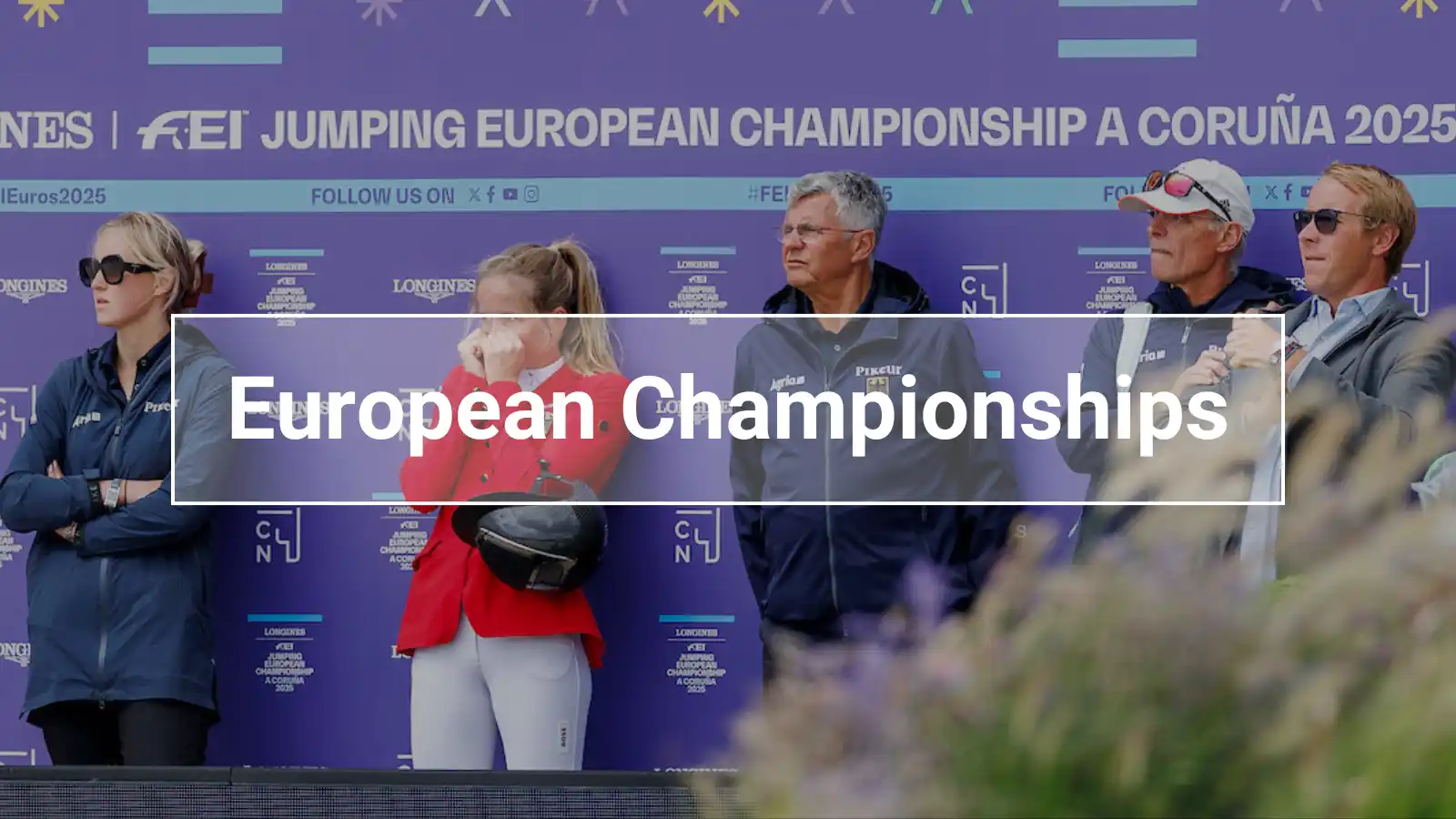 Team members and riders in front of the official sponsor wall at the 2025 European Show Jumping Championships in A Coruña — a behind-the-scenes look at the tournament action