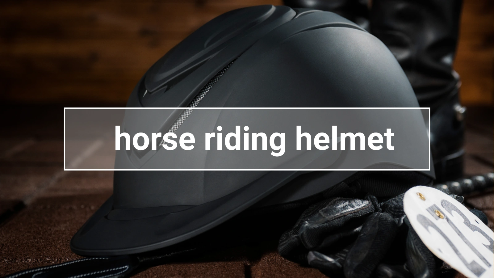 Close-up of a black horse riding helmet with gloves and number tag, symbolizing safety and competition in equestrian sports.