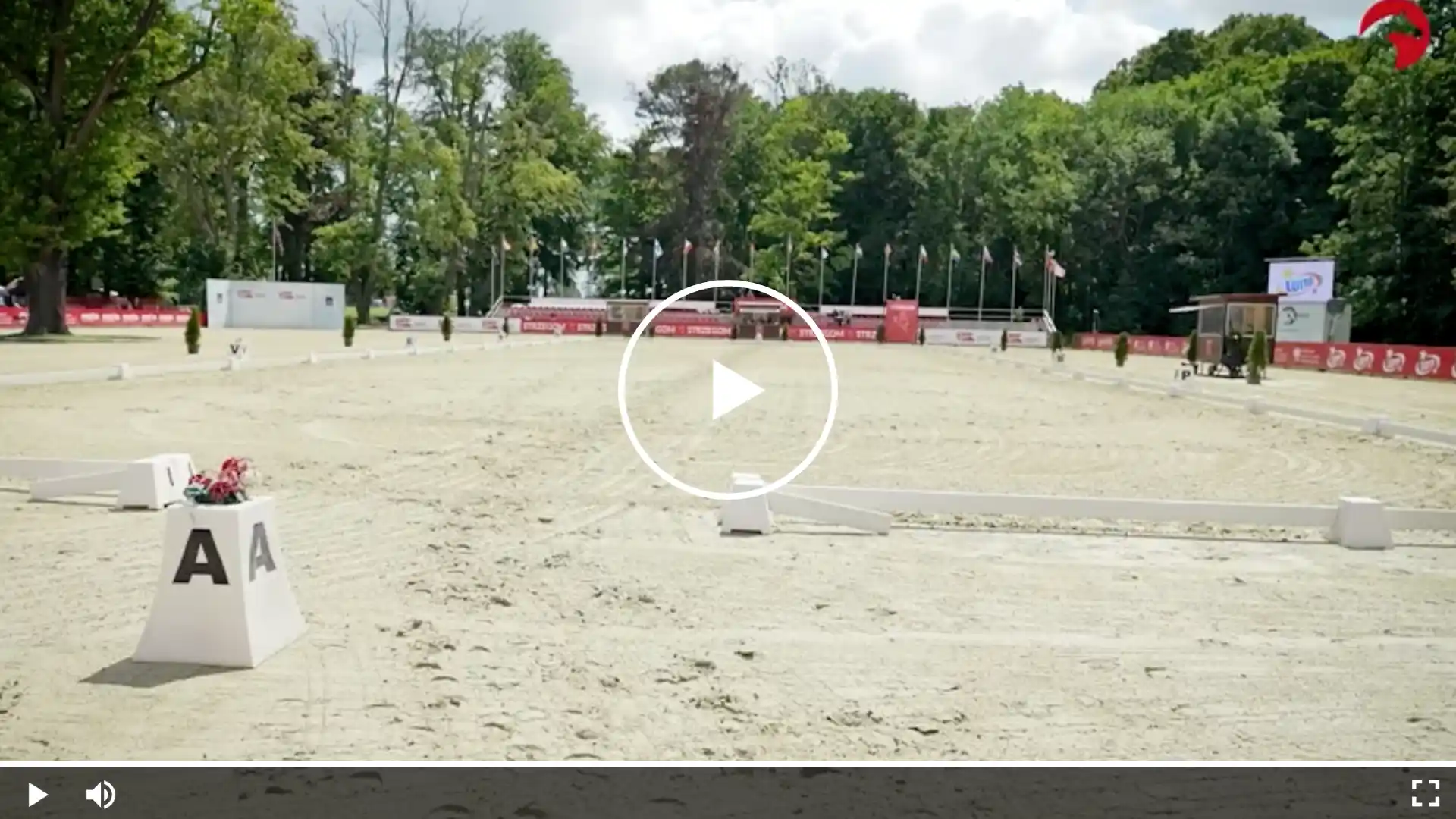 Leeres Dressurviereck bei einem Reitturnier mit Buchstabenmarkierung A, Sandboden und Zuschauerbereich im Hintergrund
