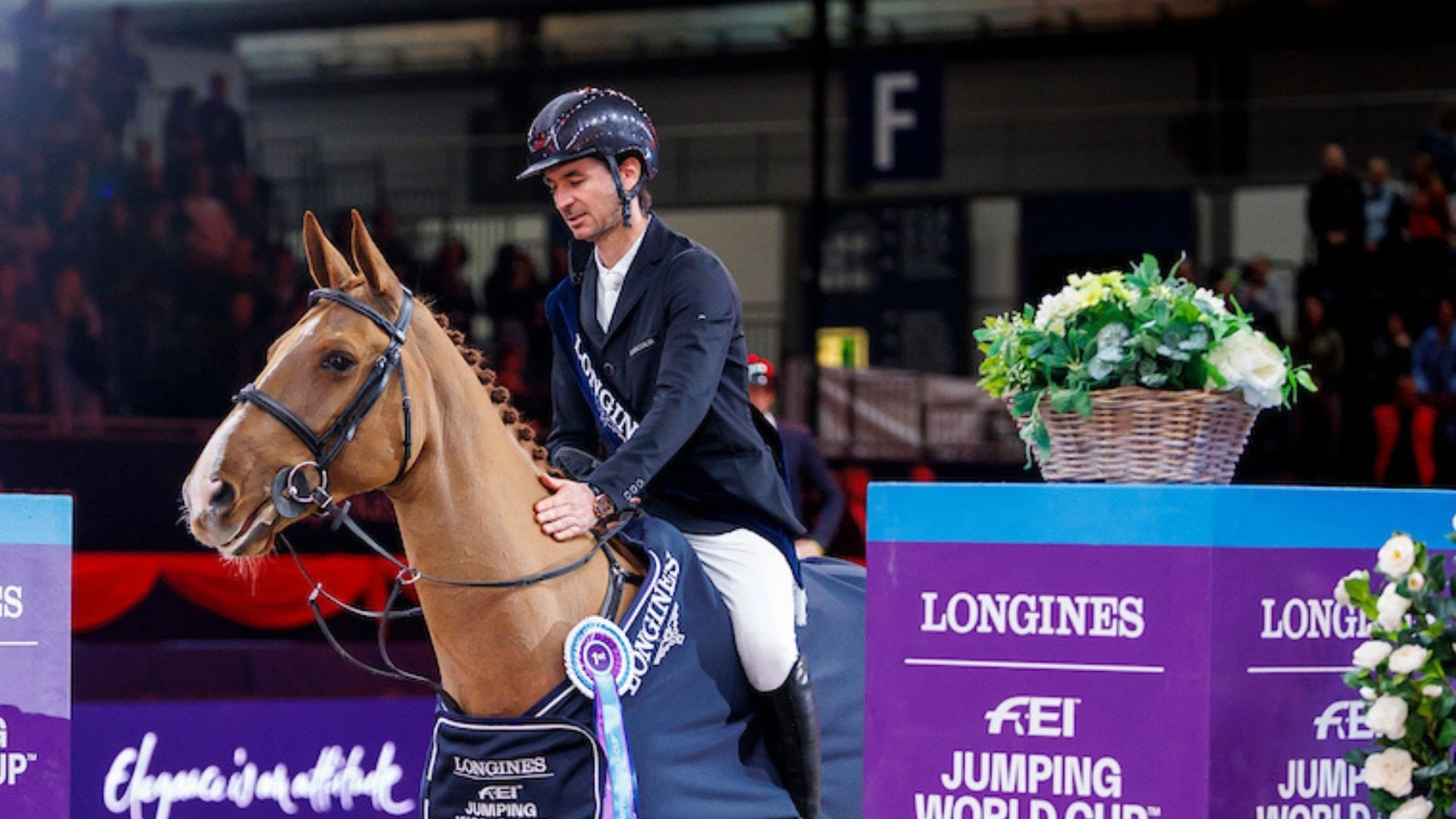 Springreiter auf einem Fuchspferd bei einer Siegerehrung im Longines FEI Jumping World Cup.
