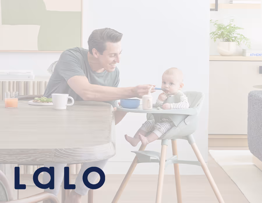 Image of a dad feeding his baby with Lalo logo overlayed