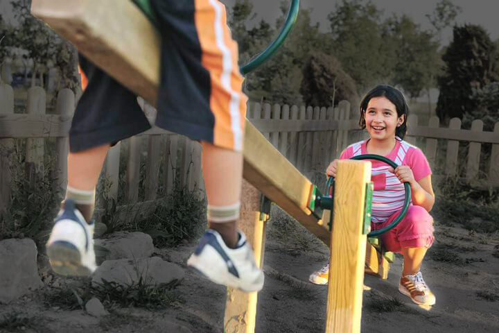 girl playing on seesaw with another kid raised out of view