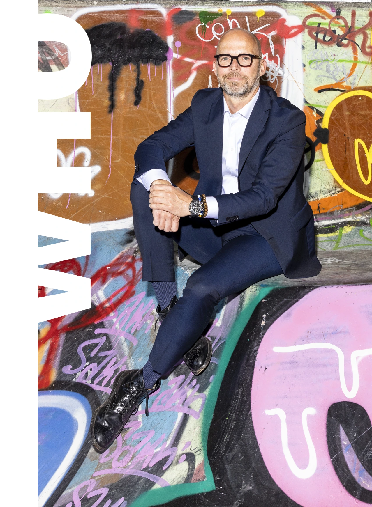 Peter Sorgenfrei sitting in front of a graffiti wall