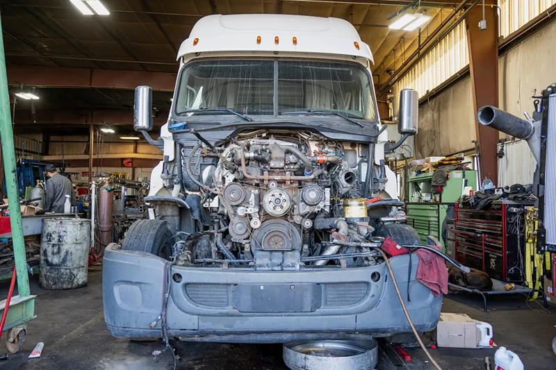 Denver work truck undergoing heavy-duty engine repair with the hood removed and engine components exposed.