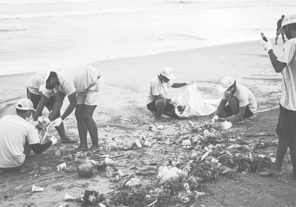 people clearing trash off of a beach