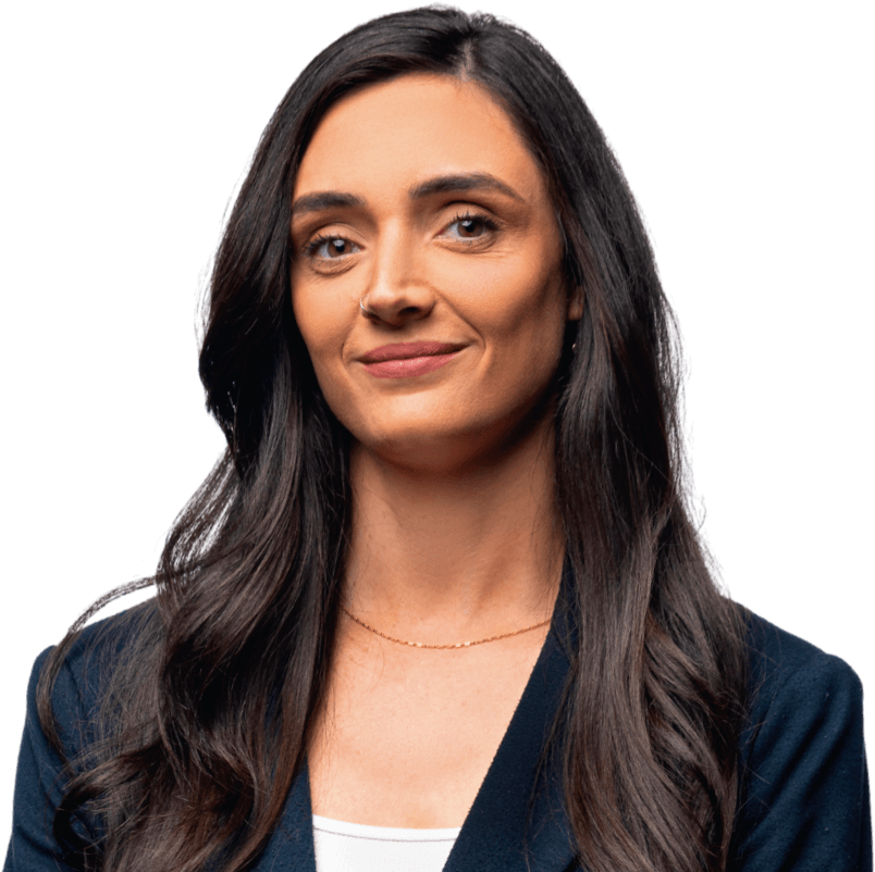 Confident woman with long dark hair wearing a navy blazer and white top, smiling slightly.