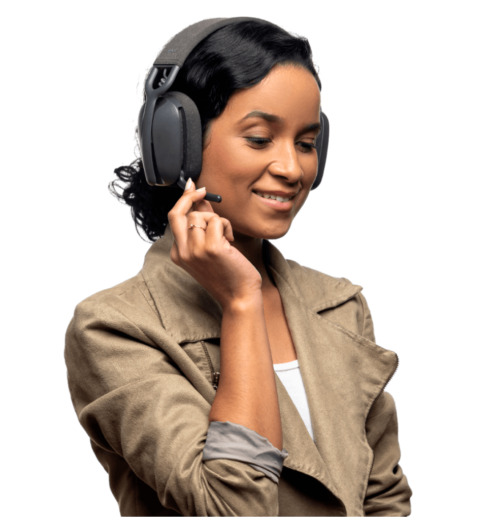 Smiling woman wearing headset with microphone and beige jacket adjusting the microphone.