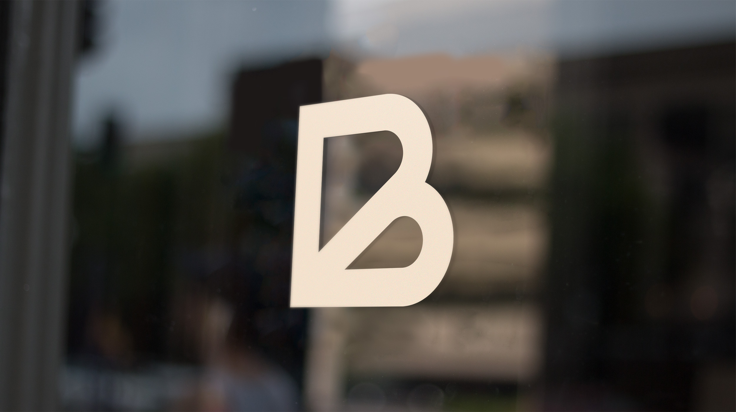 Bradley Taylor logomark appearing as a vinyl sticker on a storefront window.