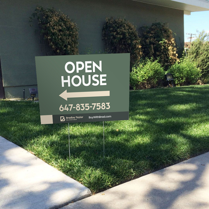Real estate lawn sign reading "open house" with an arrow directing towards the property.