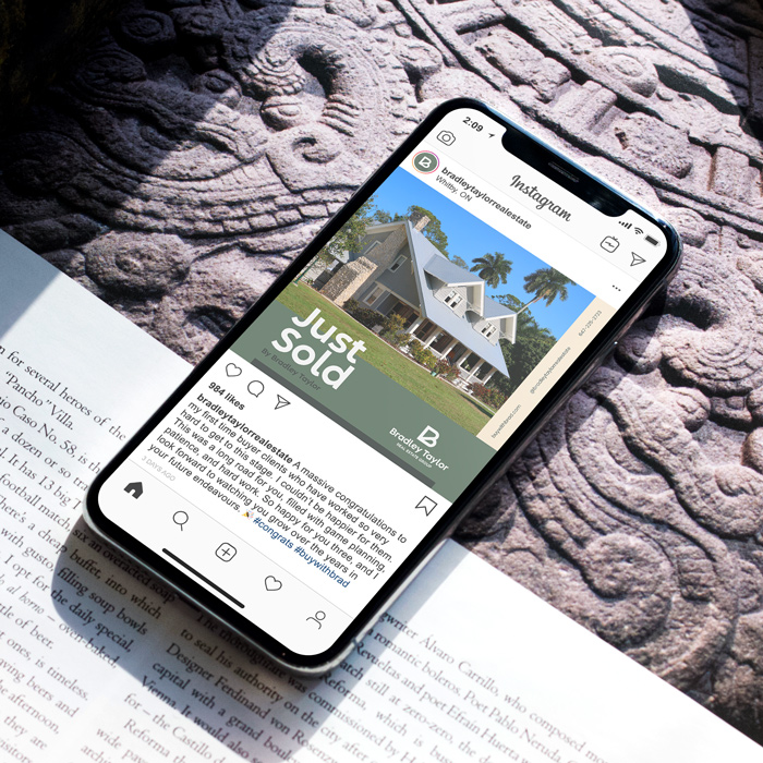 An iPhone laid across an open book displaying a Bradley Taylor Instagram graphic