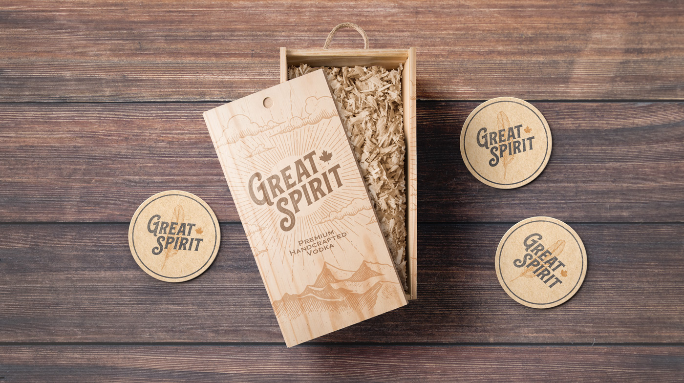 A Great Spirit packing box resting on a table with branded drink coasters.
