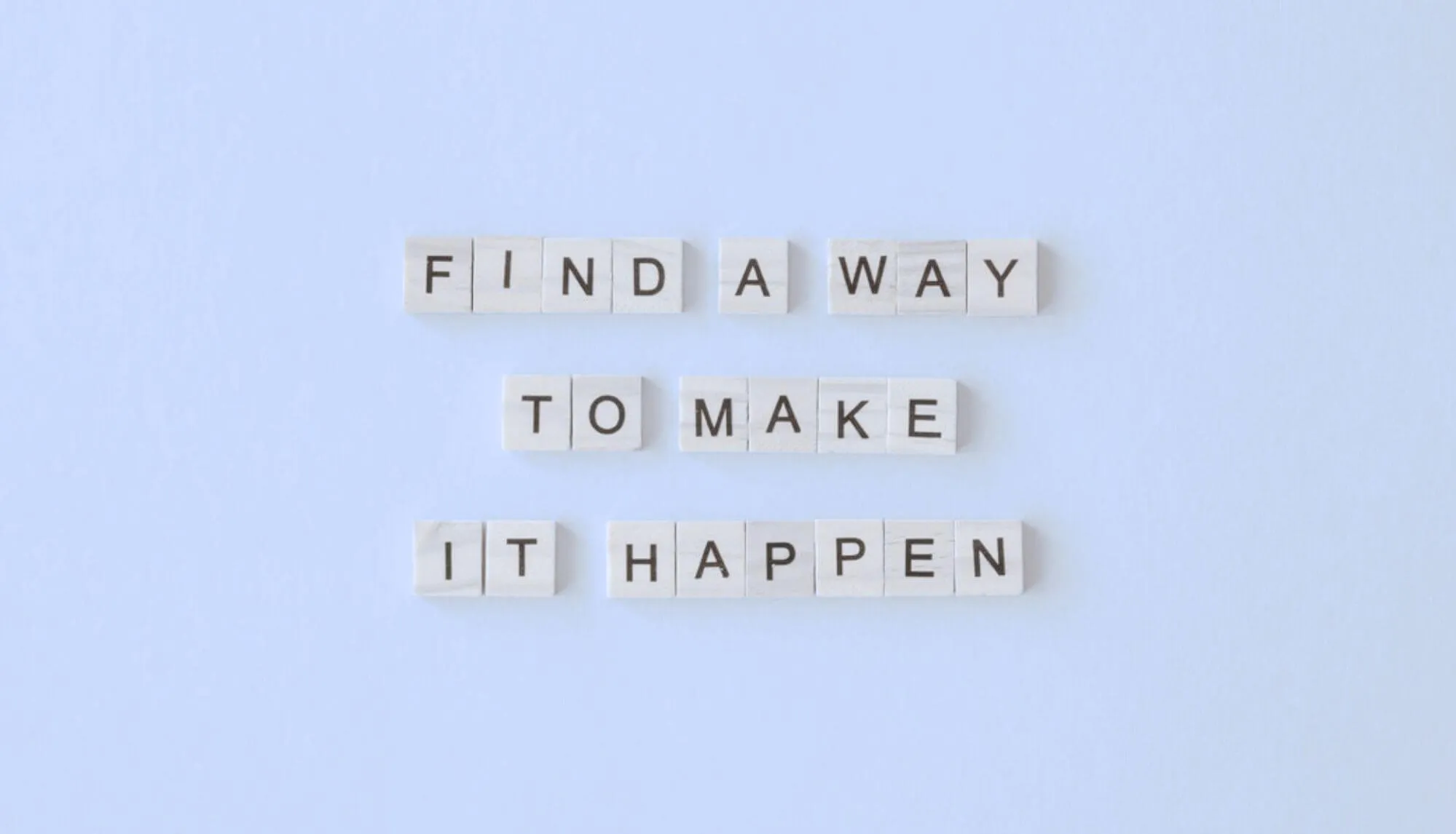 Wooden letter tiles spell out "FIND A WAY TO MAKE IT HAPPEN".