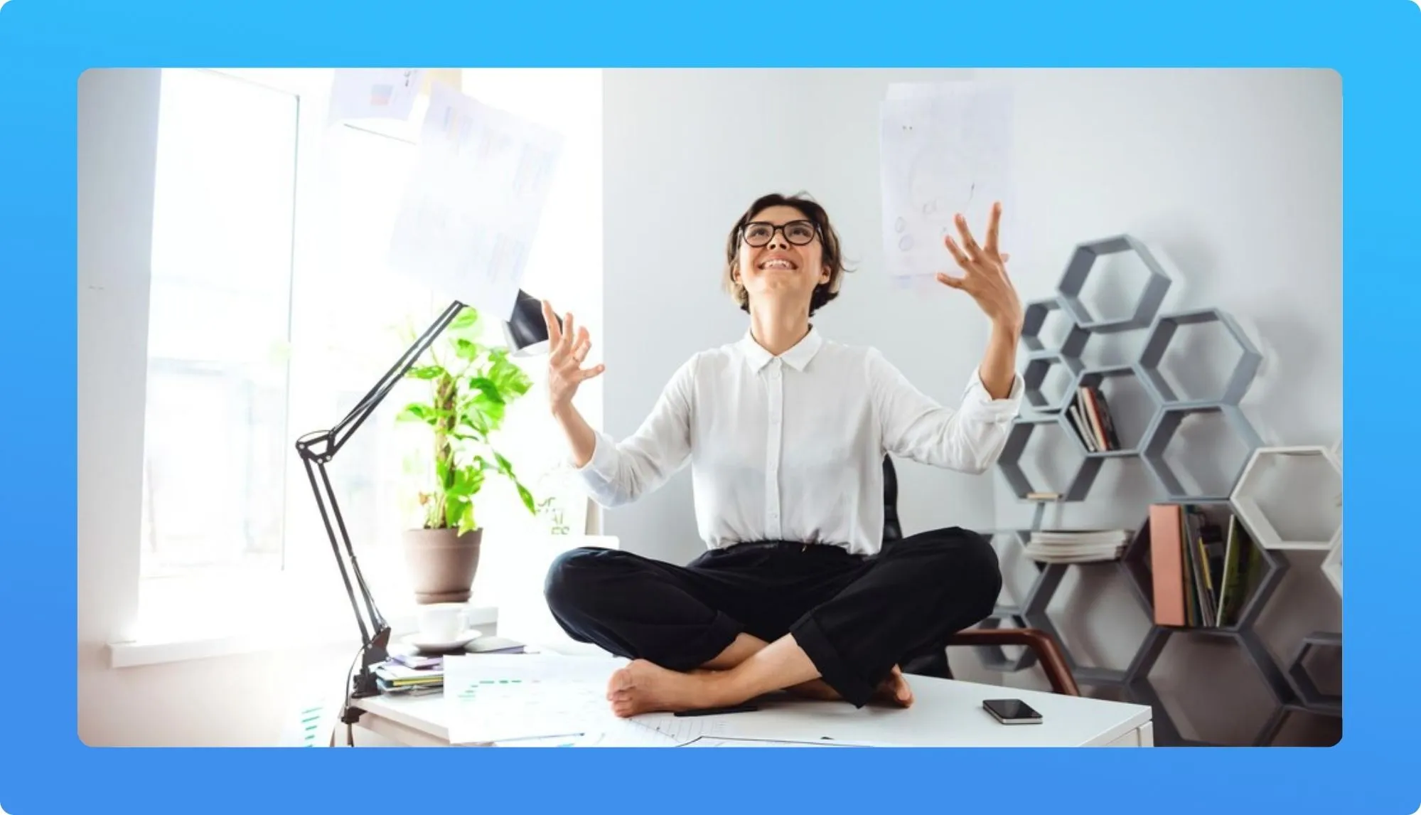 Woman meditating on desk in a bright home office.
