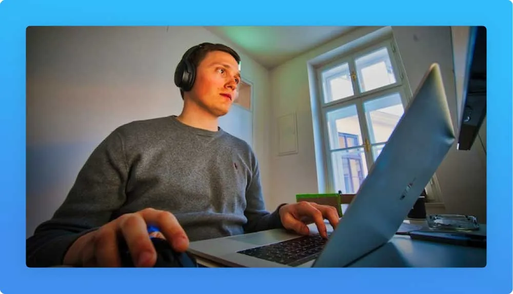 Freelancing from home, young man in headphones working on his laptop 