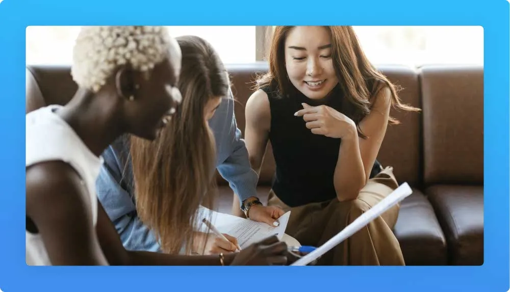 Three women from different nationalities taking notes