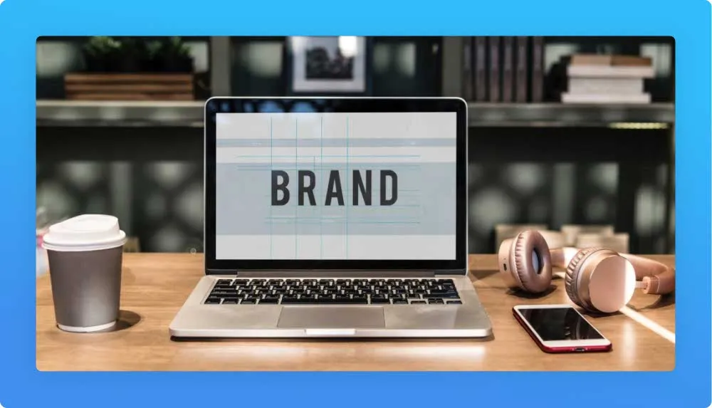 Desk with coffee, phones, mobile and Laptop displaying the word Brand
