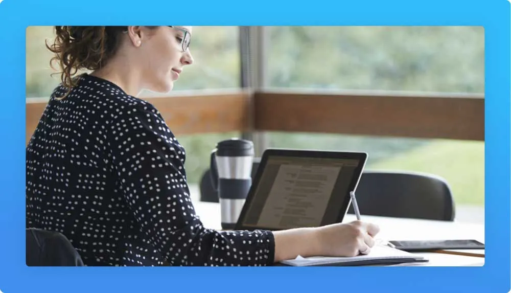 Woman writing content on notebook and laptop