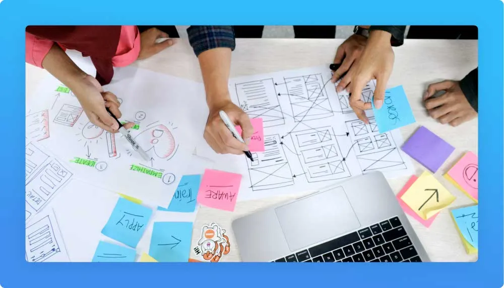 Bunch of UXUI sketches on paper, post-its, hands holding sharpie markers 