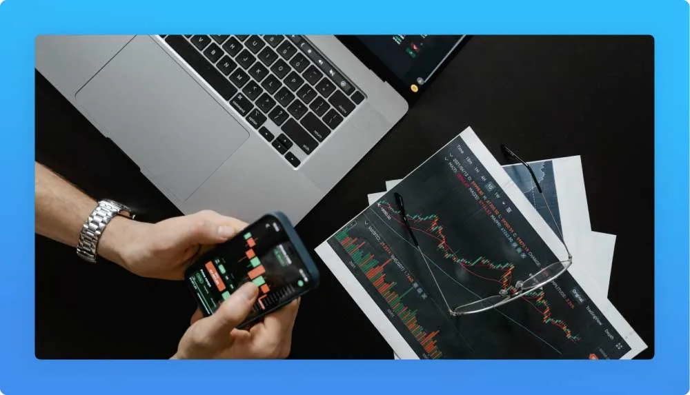 Laptop, paper work and mobile phone with marketing charts