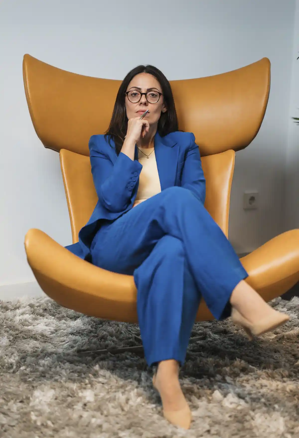 Anna Danieljan in einem blauen Anzug auf einem braunen Ledersessel sitzend.