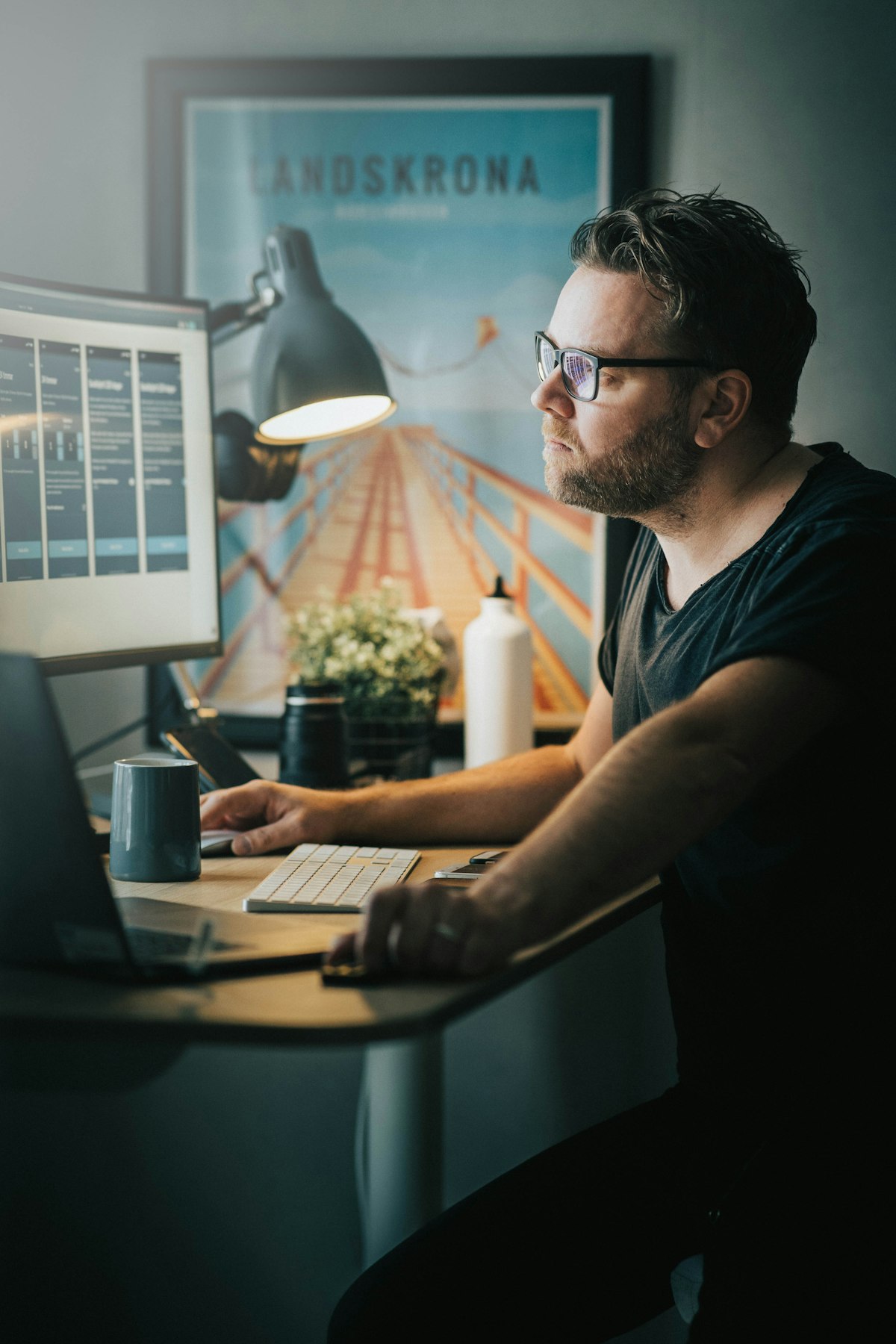 Ein Mann mit Brille arbeitet abends zu Hause am Computer.