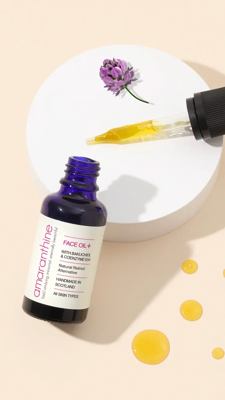 Amaranthine Face Oil+ with bakuchiol, shown with babchi plant flower and oil texture illustrating a gentle retinol alternative.
