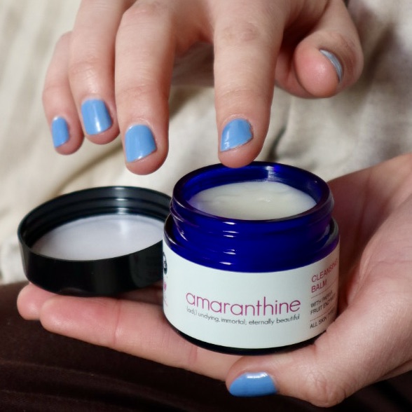 Natural cleansing balm being applied with fingertips, gentle cleanser for rosacea-prone skin