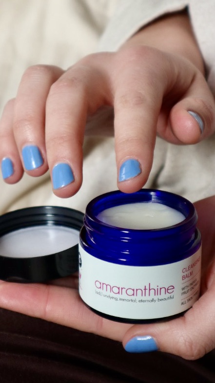 Natural cleansing balm being applied with fingertips, gentle cleanser for rosacea-prone skin