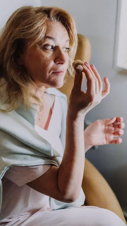 Woman applying a nourishing face oil while caring for skin as it changes with age