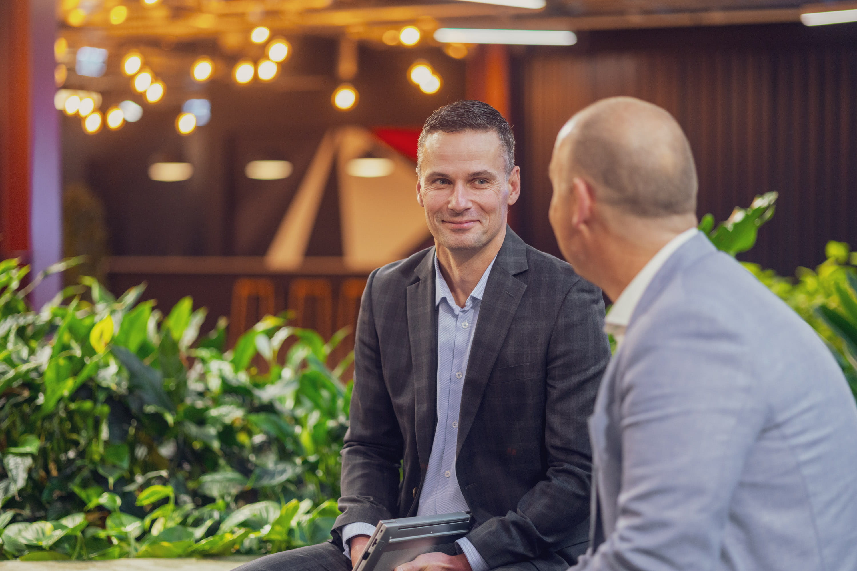 Jonny, financial adviser at Become Wealth, seated with a client (over client shoulder)
